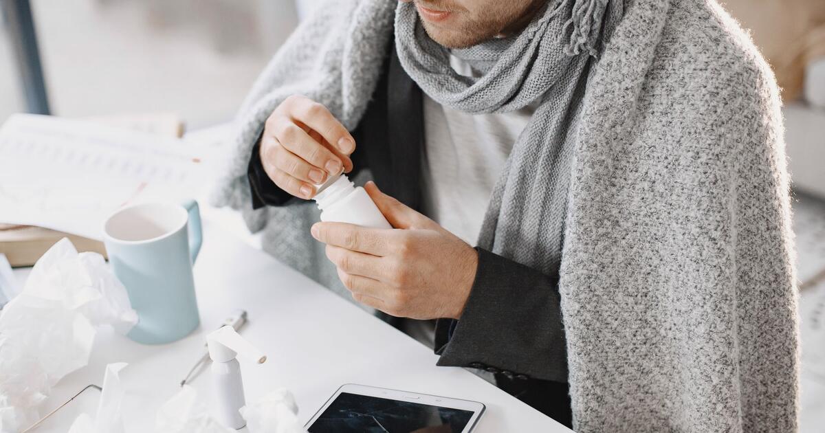 osoba pod dekom s maramicama i caj tijekom gripe