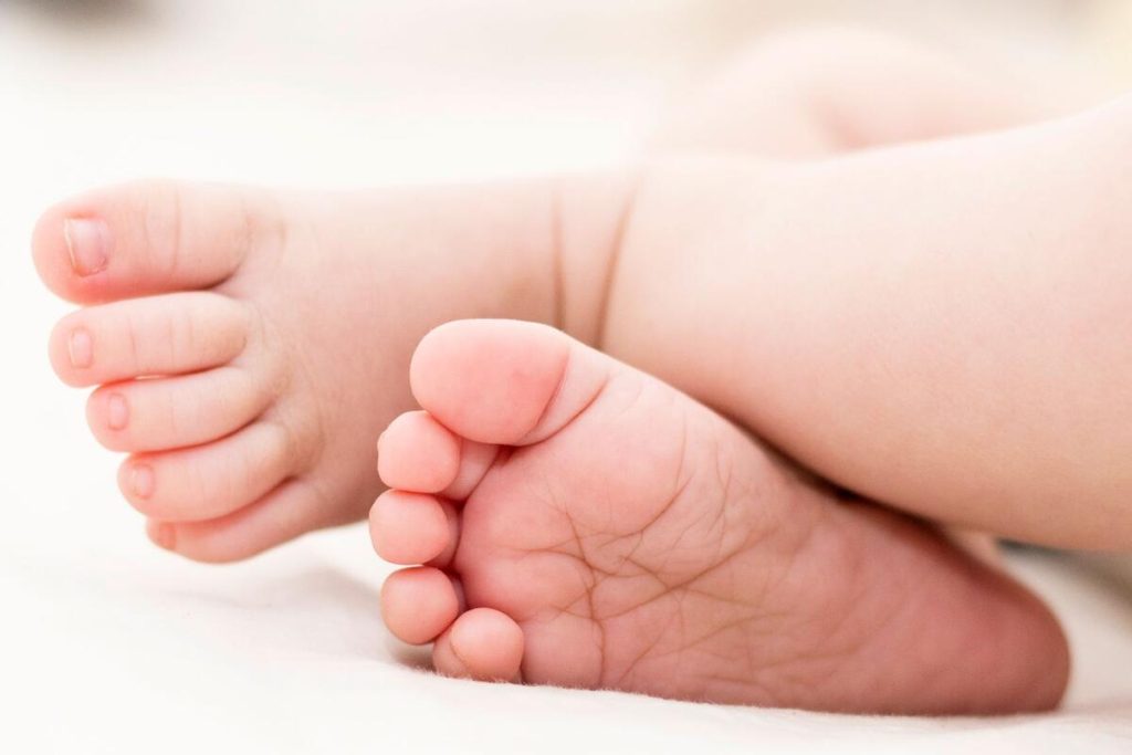 newborn baby feet in soft blanket close up