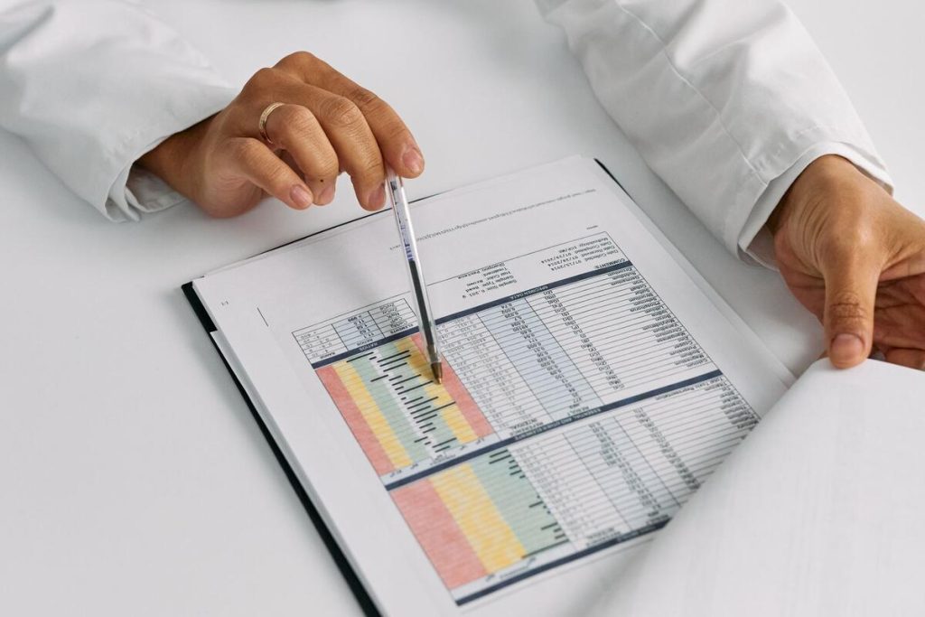 doctor reviewing medical chart with liver anatomy illustration, clinic office