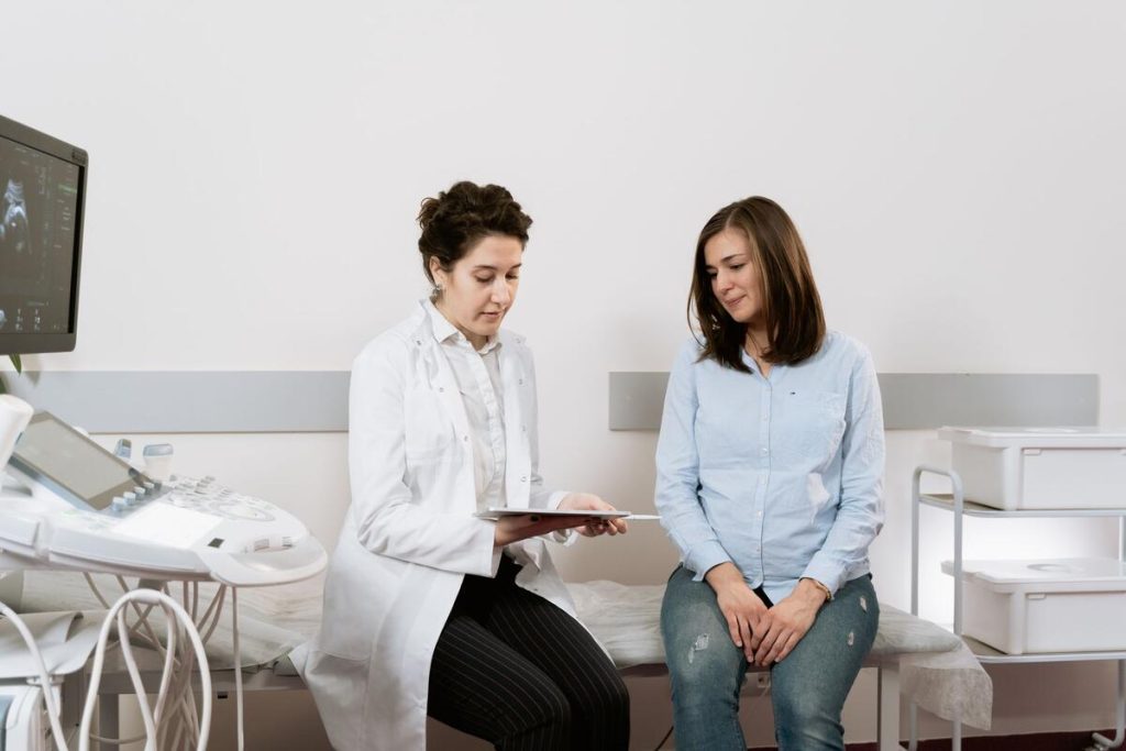 pregnant woman talking with her gynecologist in a bright medical office, no visible faces