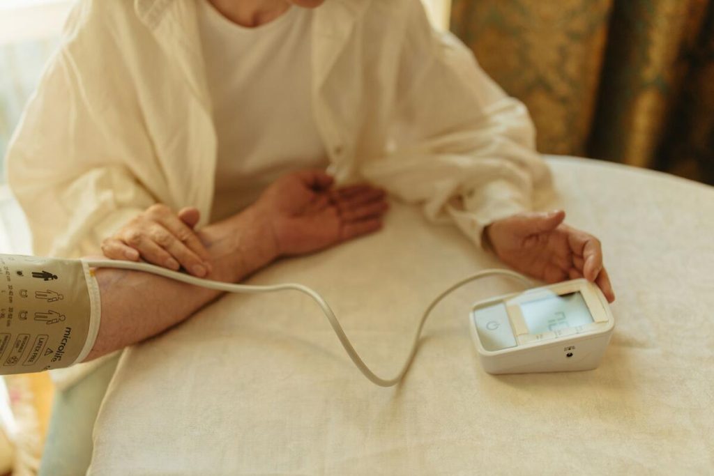 elderly person measuring blood pressure at home with digital monitor