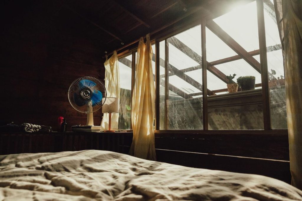 dark quiet bedroom with neatly made bed, no people