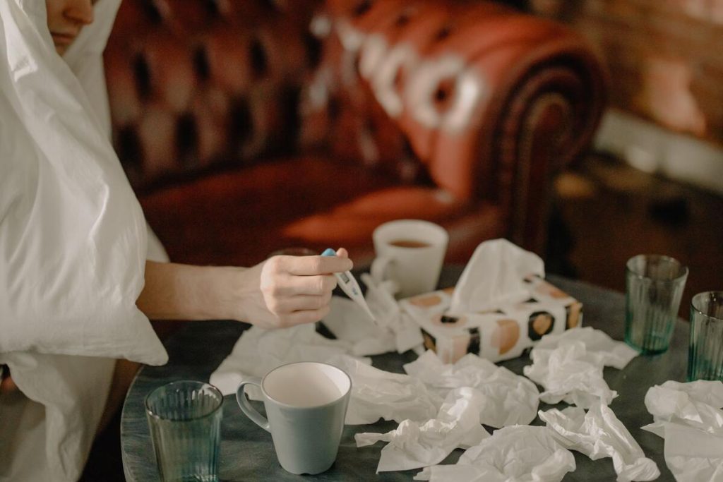 thermometer and box of tissues on a table during flu season