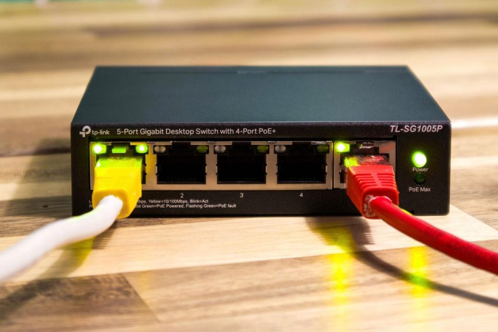 network router and ethernet cables close up on office desk, no people
