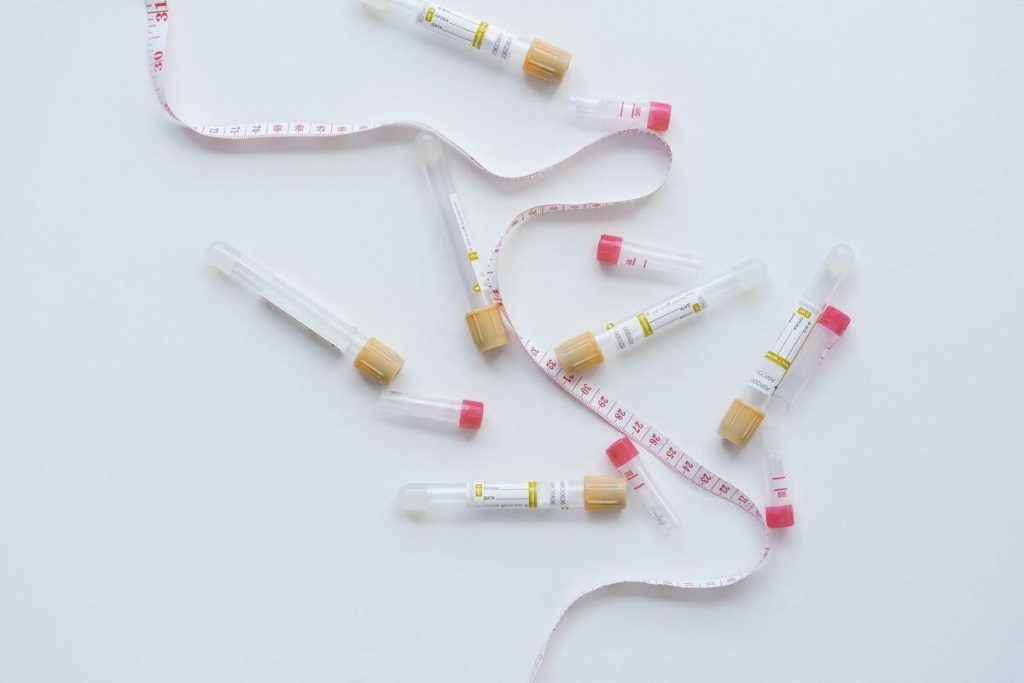 laboratory vials and insulin pen on a clean clinical table, no people