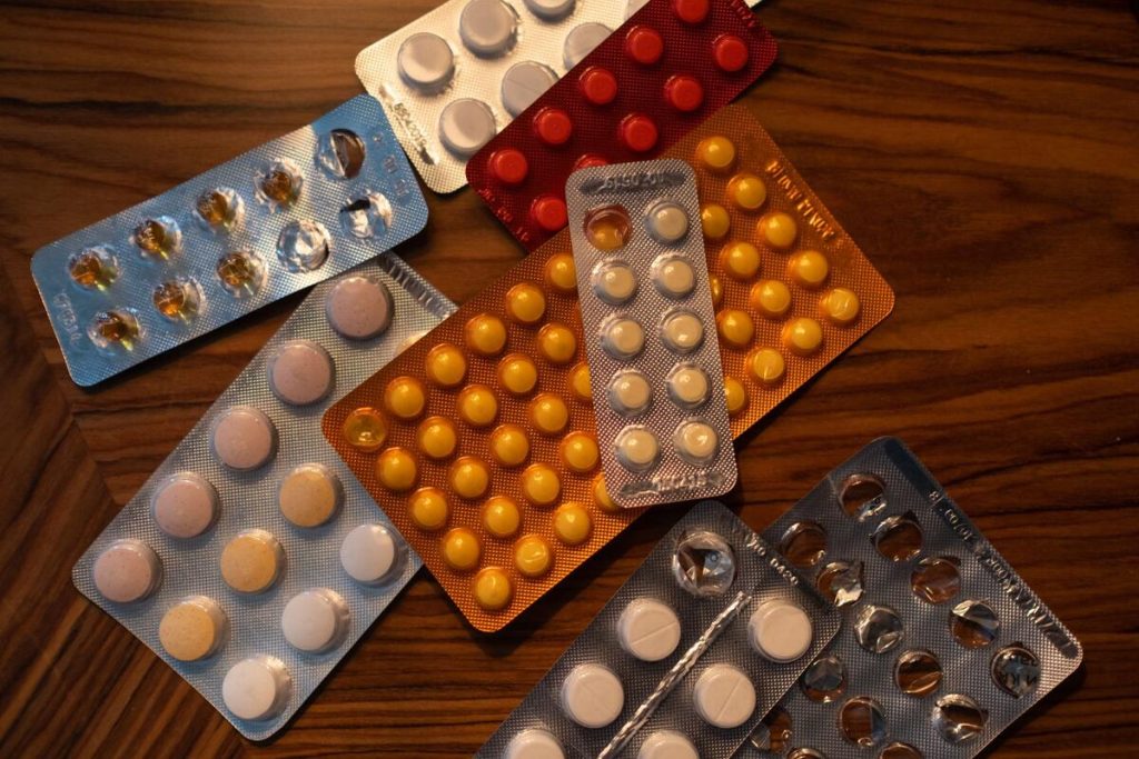 white medication tablets on a wooden table in a pharmacy, no people