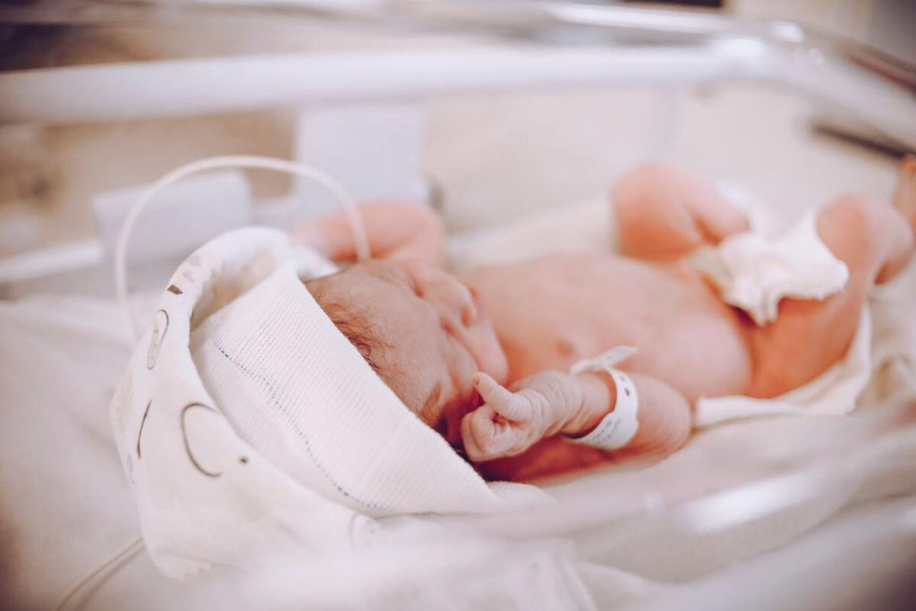 phototherapy lamp over hospital bassinet in nursery, no people