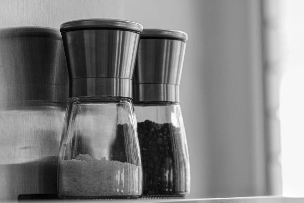 close-up of a glass of water with salt on a bathroom shelf, no people