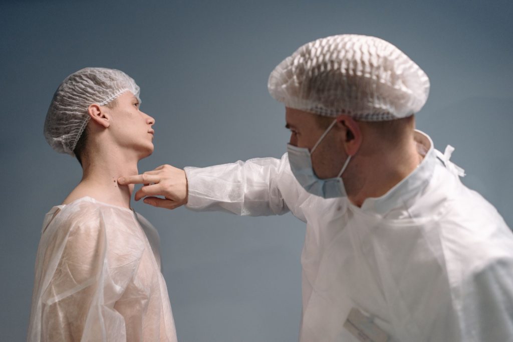 dermatologist examining mole on patient skin with dermatoscope in clinic