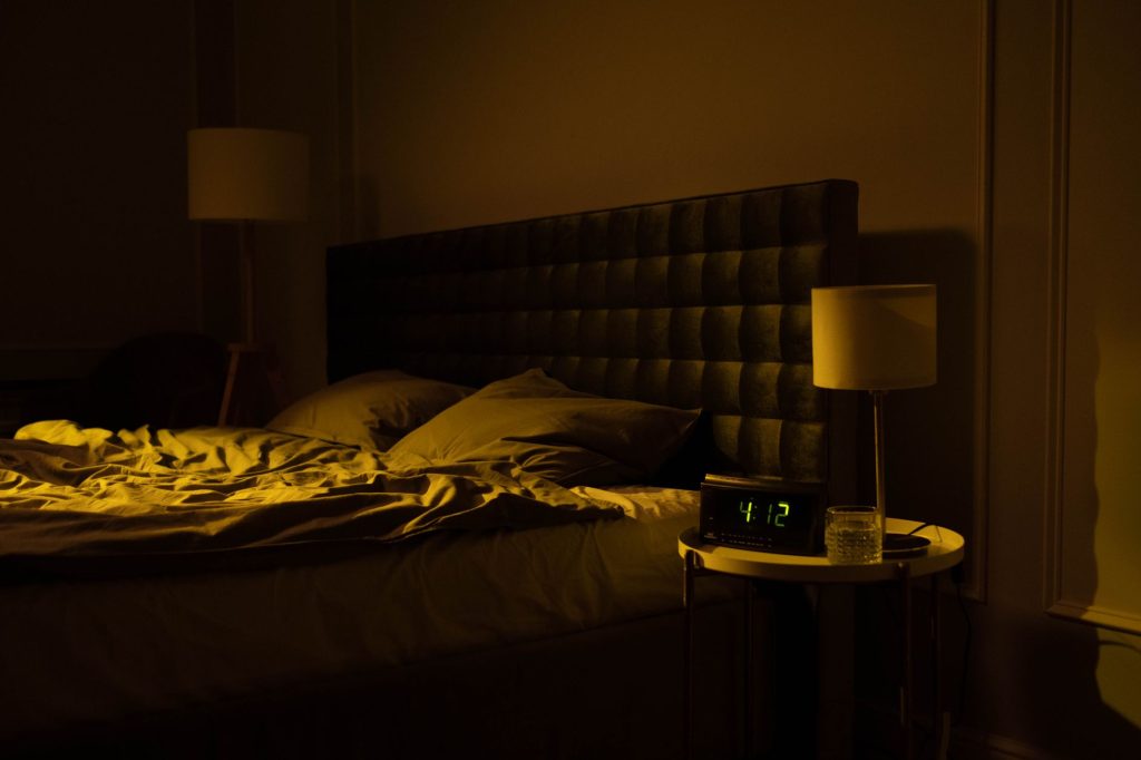 CPAP machine on a nightstand in a dark bedroom at night