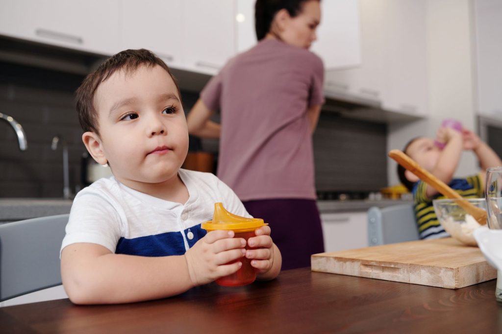 tired young mother sitting alone at kitchen table, no visible children