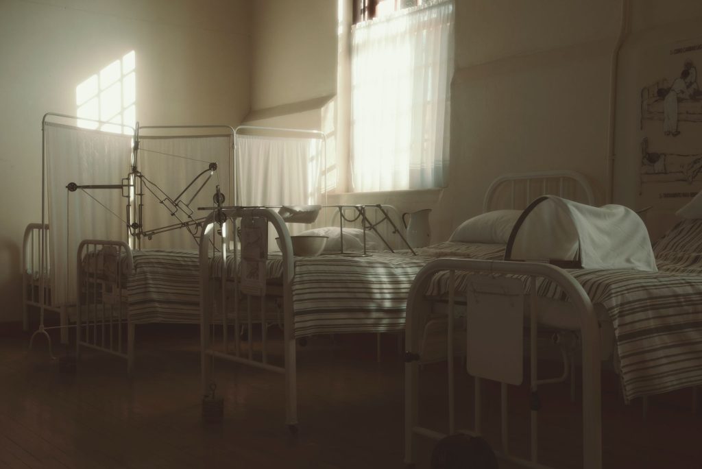empty hospital bed in bright palliative care room, no people