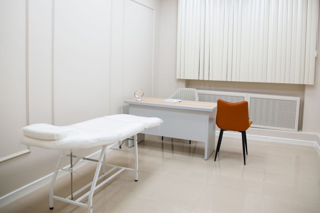 pregnant woman doctor appointment consultation room furniture, no faces