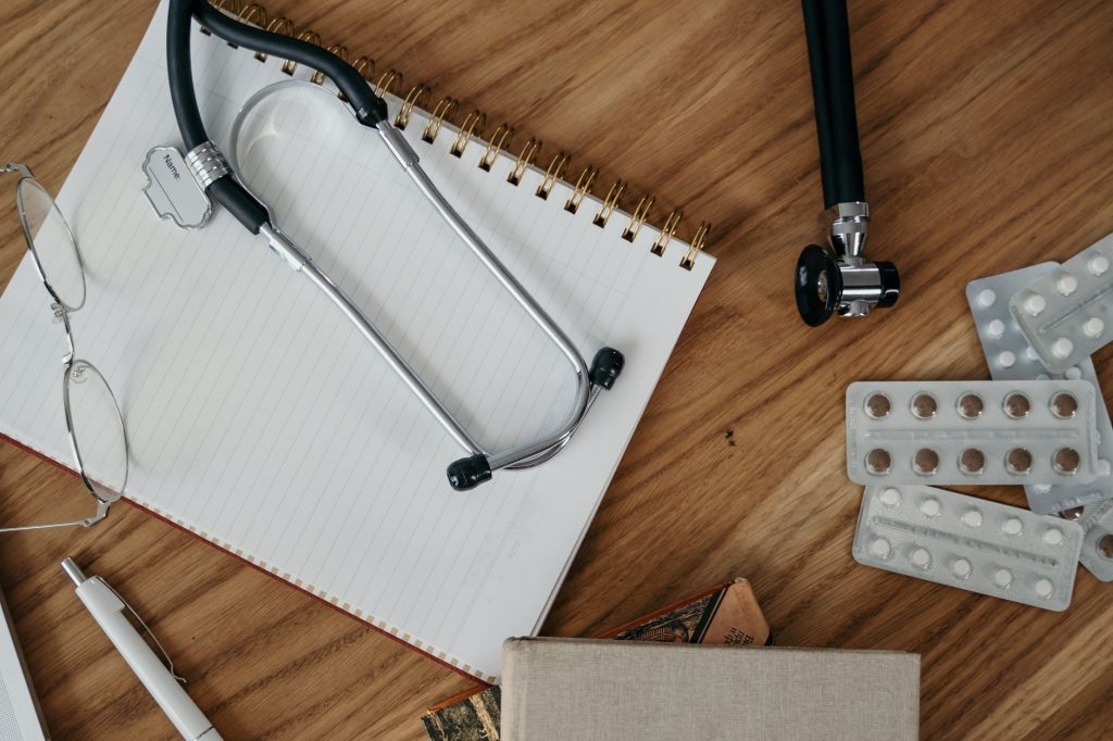 calm doctor office desk with notepad and stethoscope, no people